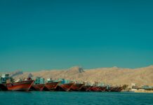 Iran’s Guards Threaten US Bases Over Hormuz Ship Escorts Boats on Gulf waters representing shipping through the Strait of Hormuz